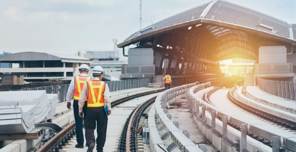 Workers in orange vests examining railway