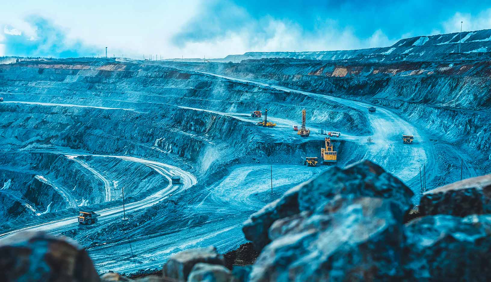 open pit mine with various vehicles and machines operating