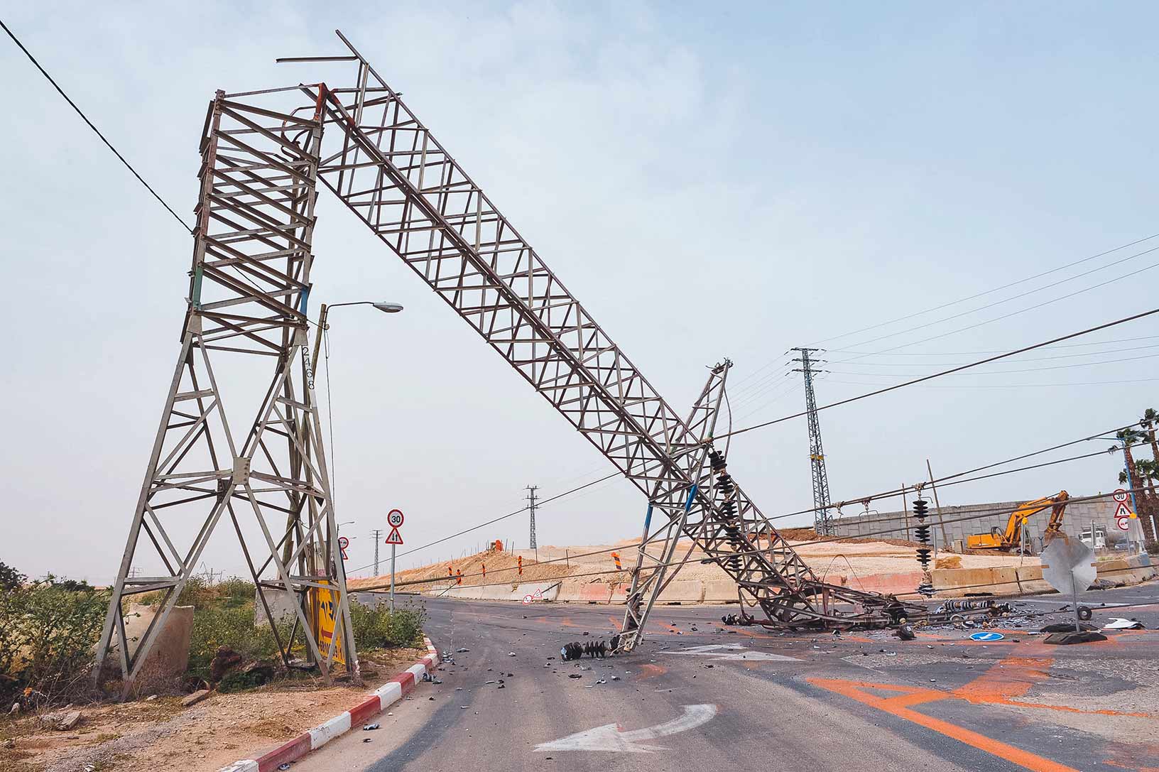 Metallstütze einer Stromleitung, die mitten auf die Straße gefallen ist