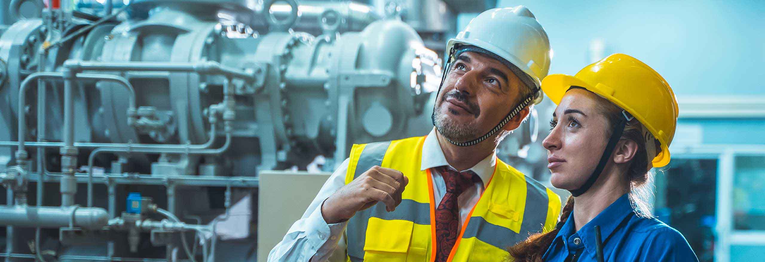 Trabalhadores técnicos conectados verificando e trabalhando em uma grande fábrica industrial.