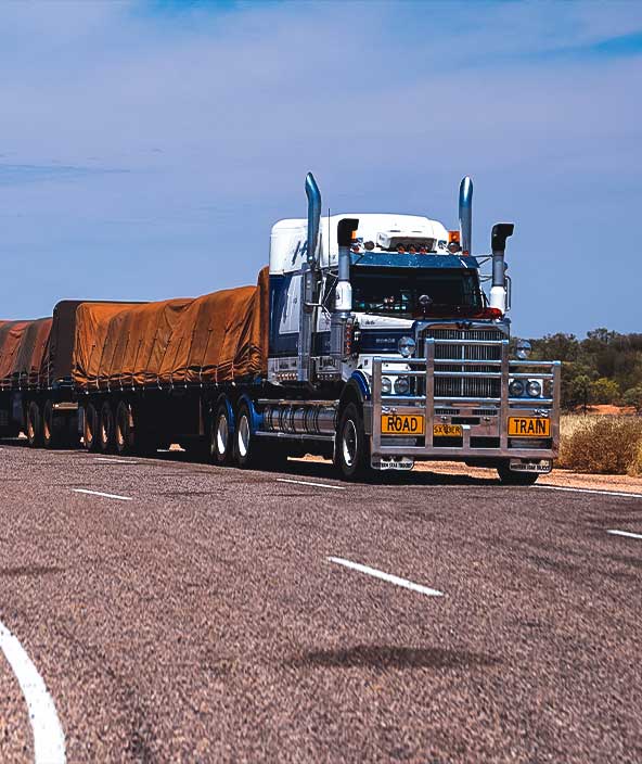 OS/OW truck pulling a train car down the highway.