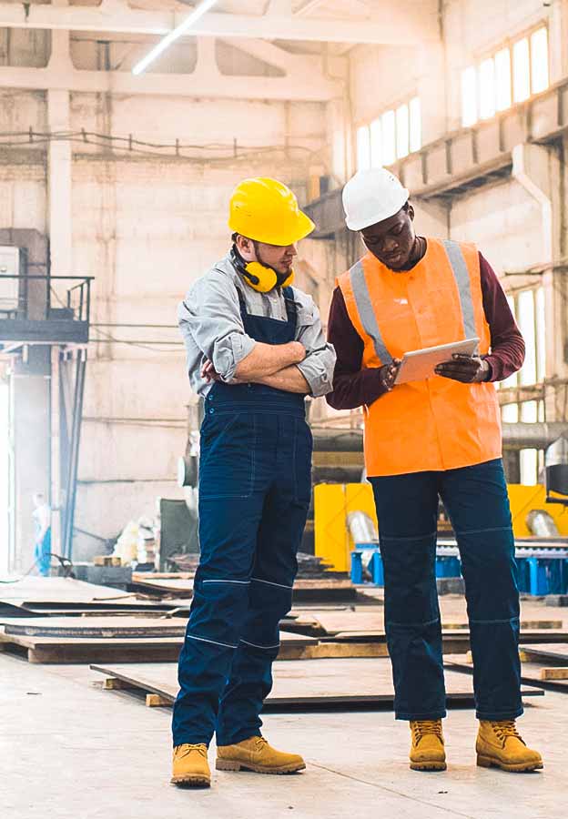 A contractor and project manager looking at an iPad on a construction site