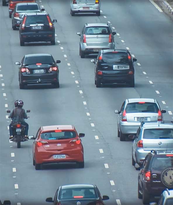 A highway full of cars and motorcyclists 